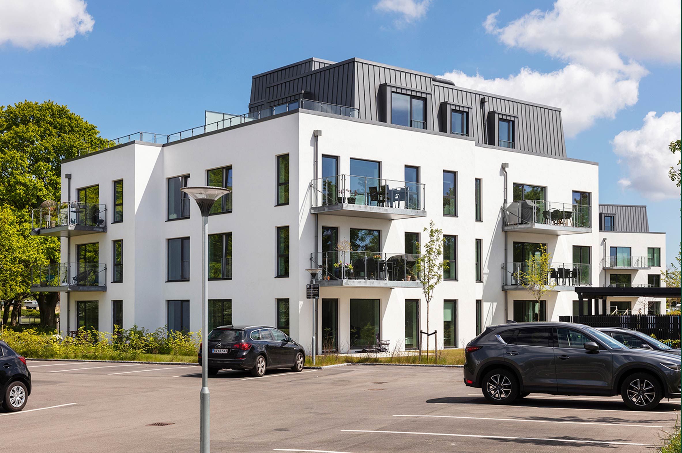 Nybyggede lejligheder med altaner og fælles parkeringsplads