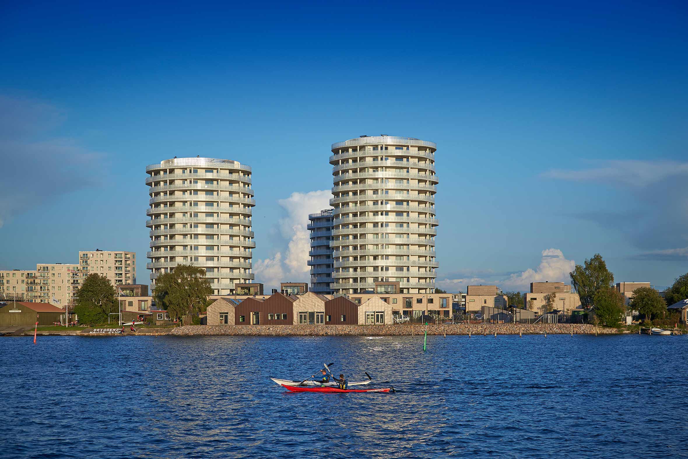 Flot vandudsigt med nybyggede tårne med lejligheder i baggrunden på Islands brygge