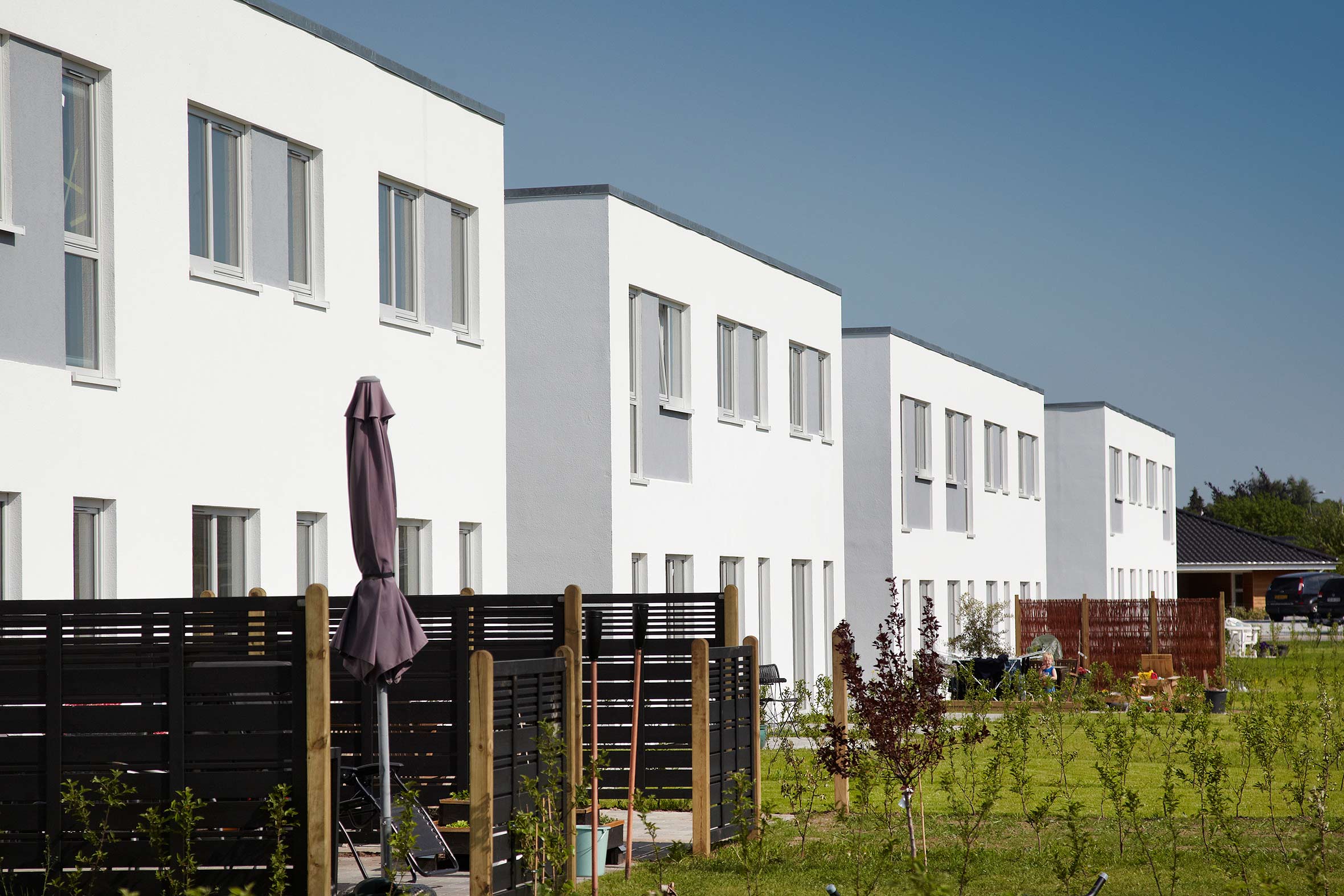 2-plans rækkehuse med hvid facade og egen have og terrasse