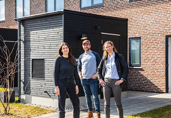 Episode 10: Velkommen... på arbejde en mand og to kvinder står foran rækkehus efter at have optaget podcast