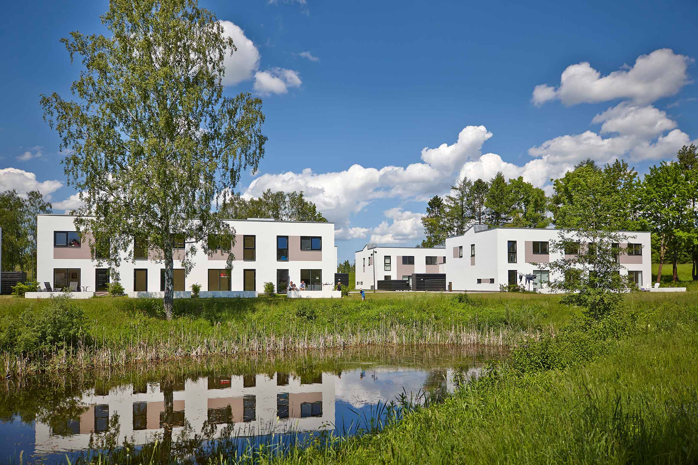 Rækkehuse i 2-plan med hvid facade og grønt område med mose i Farum